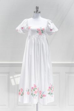 An eye catching summer dress, the Florentina features vibrant floral embroidered on the bodice and hem on a white linen-blend. A smocked elastic back and gentle a-line silhouette make for a comfortable and flattering fit. Perfect for a statement vacation piece, or to simply stun while out and about this summer! .. Deta Summer A-line Smocked Dress With Smocked Bodice, White Embroidered A-line Dress For Spring, Spring A-line Smocked Dress With Smocked Bodice, Spring Cotton Dress With Smocked Back, Feminine Summer Floral Print Embroidered Dress, Spring Square Neck Smocked Dress For Garden Party, Spring Smocked Square Neck Dress For Garden Party, Spring Cotton Smocked Dress For Brunch, Feminine Cotton Dress With Smocked Bodice