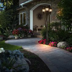 a house with flowers in the front yard and walkway leading up to the entry door