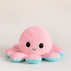 a pink and blue stuffed animal on a white background