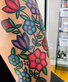 a woman's arm with flowers painted on it