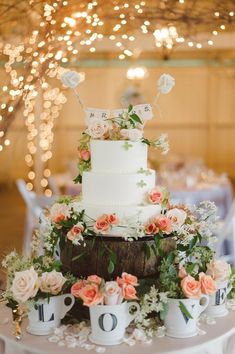 a wedding cake with flowers and greenery on top