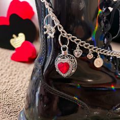 Queen of hearts chain, queen of hearts boot chain, queen of hearts jewelry, Alice in wonderland, Alice in wonderland boot chain, queen of hearts charms. If you love Alice in wonderland and queen of hearts this is a one of a kind unique boot chain. Chain is 8.5" long with a 2" dangle. The listing is for one chain to be worn on your right boot the boot is not included in the purchase. It is just for demonstration purposes only. The LETTER CHARM "Q" is subject to change to another variant of a "Q" charm. But it will be compatible and look just as beautiful.  Take care of your jewelry and it will gleam for years. While every piece of jewelry looks beautiful, it can end up loosing its luster if not cared for properly. If you want your jewelry to look as good as new, then you need to take excell Queen Of Heart, Alice In Wonderland Alice, Hearts Jewelry, Wonderland Alice, Boot Chains, Unique Boots, Halloween Inspo, Letter Charm, Heart Chain