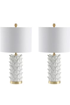 two white lamps with gold accents on each one and a white shade on the other