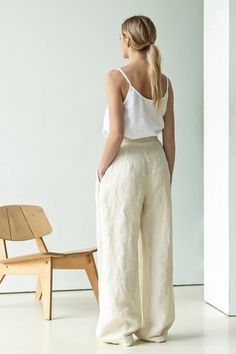 "High waisted linen palazzo pants with pockets. These linen trousers share many elements of suit pants not present in traditional linen pieces: a belt ribbon, zip closure, pleats, slant pockets, etc. Pick these wide-leg pants and you will shine in classy elegance beloved by Italians. Complete your outfit with a matching linen jacket and a classic or minimalistic blouse. ABOUT US LINEN ID was born from desire to embrace things that actually matter. We aim to create sustainable garments that offer White Linen Wide-leg Pants, Solid Linen Trousers, White Linen Wide-leg Bottoms, White Linen Wide Leg Bottoms, Solid Linen Wide-leg Pants, Relaxed Fit Linen Ankle-length Culottes, Relaxed Fit Linen Wide-leg Culottes, Ankle-length Linen Culottes With Pockets, Relaxed Fit Linen Culottes With Wide Legs