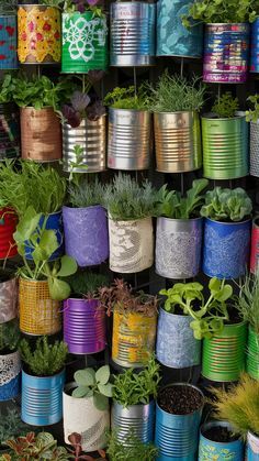 many tin cans are stacked on top of each other with plants growing in the middle