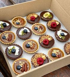 a box filled with lots of desserts on top of a wooden table