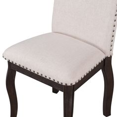 a white upholstered chair with wooden legs and studded trimmings on the back