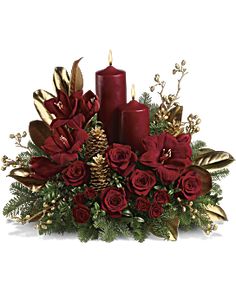 a christmas centerpiece with red candles and greenery