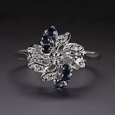 Why we love it:This vintage diamond and sapphire cocktail ring features diamonds and sapphires set in a spiraling design resembling a glittering galaxy.Highlights:- Original vintage- 0.12ct of bright white and completely eye clean diamonds with grades of F-H VS1-SI1- 0.30ct of rich blue sapphires- Handcrafted 14k white gold settingDimensions:13.5mm across (north-south) and 6.7mm from the finger to the top Galaxy Highlights, Sapphire Cocktail Ring, Diamond Cocktail Ring, Vintage Sapphire, Diamond Cocktail Rings, North South, Sapphire Diamond, Vintage Diamond, Cocktail Ring