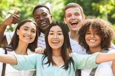 a group of young people standing next to each other with their arms in the air