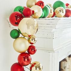 christmas ornaments are hanging on the fireplace mantel