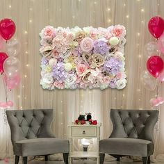 two chairs in front of a backdrop with balloons and flowers on the wall behind them