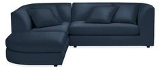 a blue couch with pillows on it and a footstool next to it,