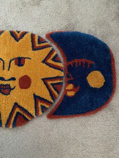 two rugs that have faces on them, one is blue and the other is yellow