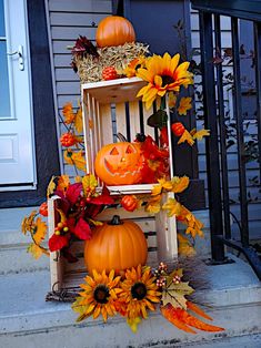 a porch decorated for halloween with pumpkins and sunflowers