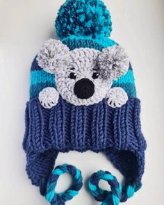 "Knit winter hat with folded brim, earflaps, braids, pom pom and crochet KOALA applique Size: Child size 19- 21''   Color: Blue in stripes with gray applique Materials: wool acrylic yarn You can add a Fleece band lining inside this hat. Add to cart: https://www.etsy.com/listing/1544868515/add-on-listing-fleece-lining This hat is READY TO SHIP! Please read my SHOP'S POLICIES about shipping here: https://www.etsy.com/shop/2mice/policy ------------------------------------------------------ If you l Fun Brimmed Winter Hat, Fun Winter Brimmed Hats, Playful Warm Bonnet Cap, Cute Brimmed Winter Bonnet, Adjustable Knitted Beanie With Ear Flaps, Winter Brimmed Hat In Acrylic Yarn, Playful Hand Knitted Winter Hat, Hand Knitted Winter Hats With Ear Flaps, Winter Hand Knitted Hats With Ear Flaps