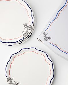 two plates with red, white and blue designs on them next to a napkin holder