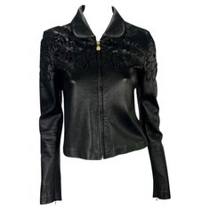 Presenting a sleek black Gianni Versace leather jacket designed by Donatella Versace. This collared leather jacket features a flat, rounded collar, cut floral design, and Medusa logo zipper pulls. The unique floral cut-out details on the coat have a layer of black mesh under the leather, maintaining the dark look. Approximate measurements: Size - 40IT Shoulder to hem: 20” Bust: 32” Waist: 30” Shoulder to cuff: 25" Underarm to cuff: 19" Spring Evening Leather Jacket, Spring Long Sleeve Leather Jacket For Evening, Designer Long Sleeve Leather Jacket For Spring, Designer Leather Jacket For Party, Spring Evening Biker Jacket With Long Sleeves, Luxury Fitted Biker Jacket For Spring, Versace Leather Jacket, Versace Leather, Vintage Designer Bags