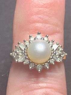 Exquisite vintage Diamond and Pearl ring crafted in 14K yellow gold. Featuring a white pearl  with vibrant lustre, The ring is complemented with diamonds consisting of round and baguette cut diamonds.  22 Diamonds weigh apx. .75 carats.   Currently a US size 7 and sizeable.  Excellent Condition.    Vintage pre-owned in very good condition. The finest quality of natural pearls have been highly valued as gemstones and objects of beauty for many centuries. Because of this, pearl has become a metaphor for something rare, fine, admirable and valuable. Pearls are the most time-honored and traditional of the June birthstones. Formal Cluster Ring With Baguette Diamonds, Formal Baguette Diamond Cluster Ring, Round Diamond Pearl Ring, Elegant Cluster Ring With Baguette Diamonds, White Pearl Ring With 17 Jewels For Formal Occasions, Vintage White Pearl Ring With Brilliant Cut, High Luster Diamond Wedding Rings, Elegant Cluster Pearl Ring For Formal Occasions, Elegant Formal Cluster Pearl Ring