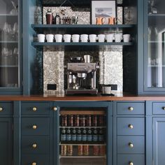 a coffee bar with blue cabinets and gold knobs on the doors is pictured in this image