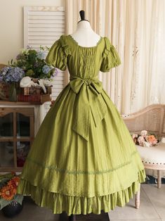 This price includes a dress and a green bowknot hairclip (not for sale).  Embrace timeless elegance with this enchanting Olive Green Puff Sleeves Classic Lolita Princess Tea-Length Dress. Designed for the true Lolita aficionado, this dress features delicately puffed sleeves and a flattering tea-length skirt that exudes sophistication and charm. The back boasts a comfortable shirring detail, ensuring a perfect fit for all body types. Whether you're attending a tea party, a cosplay event, or simpl Green Puff Sleeve Dress For Wedding, Green Puff Sleeve Dress In Cottagecore Style, Green Vintage Victorian Dress With Ruffles, Vintage Green Puff Sleeve Dress, Vintage Green Dress With Puff Sleeves, Elegant Green Vintage Dress With Ruffles, Elegant Green Vintage Dress For Garden Party, Green Vintage Dress With Ruffles For Garden Party, Green Cottagecore Dress With Ruffles