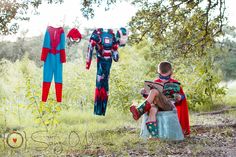 two children are sitting on a bench in the grass with clothes hanging up to dry