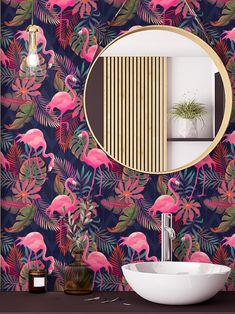 a bathroom with pink flamingos on the wall and a round mirror in front of it