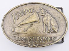 a brass belt buckle with an image of a dog and a musical instrument