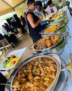 a buffet table filled with lots of different types of food and people in the background