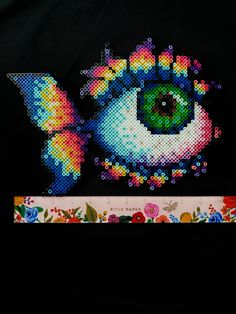 an image of a cross stitched eye on a black background