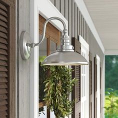 an outdoor light hanging from the side of a house