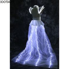 a white dress with fairy lights on it and an angel in the back is lit up