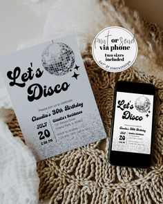 a cell phone sitting on top of a blanket next to a flyer for let's disco