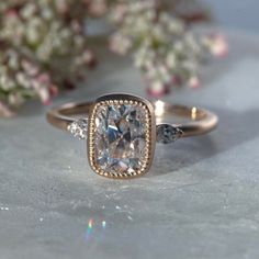 a close up of a ring on a table with flowers in the background