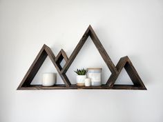 three wooden shelves with candles and plants on them in the shape of triangle shaped triangles