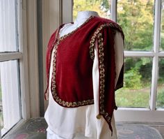 I can imagine this beautiful antique Edwardian children's waistcoat serving as a costume for one of the three kings in a Christmas pageant or for a child performing in the Nutcracker Suite, as an Alladin, Renaissance Prince, or Jester Halloween costume, or as formal wear for a child attending a Christmas wedding or other formal event.  It is hand sewn from deep red velvet, with metallic gold braid trim.  It has a cropped length and flaps ending in points covering the shoulders.  A few gold coins are attached here and there.  It is fully lined in mauve cotton fabric.  Closes with a singe hook and eye at the neckline.  Fits like a size small. I prefer not to guess the size based on numbers, since the size of children can vary wildly. Please check measurements carefully for correct fit. Measu Vintage Winter Costume Vest, Vintage Winter Vest For Costume, Jester Halloween Costume, Jester Halloween, Narnia Costumes, Pageant Costumes, Christmas Pageant, Velvet Vest, Medieval Costume