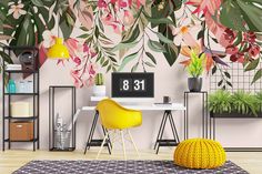 a desk with a clock on it next to a wall covered in plants and flowers