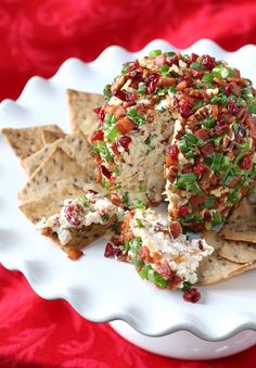 a white plate topped with crackers and cheese covered in toppings on top of it