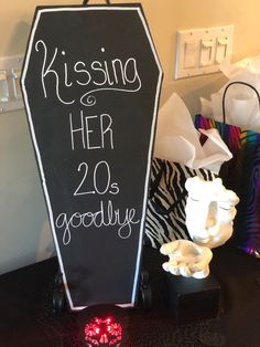 a sign that says kissing her 20 goodbye next to some other items on a table