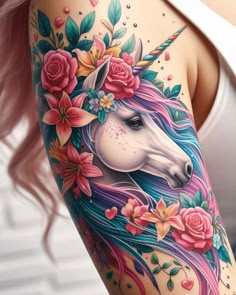 a woman's arm with an unicorn and flowers tattoo design on the left side of her body