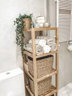 a wooden shelf filled with towels next to a toilet