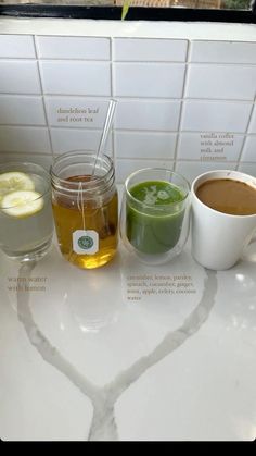 three different types of drinks on a counter with labels in the shape of a heart