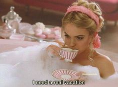 a woman in a bathtub drinking from a cup with the caption i need a real vacation