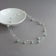 This mint green, multi-strand necklace has been created using jade beads and sparkling Swarovski crystals. This aqua three strand necklace would make the perfect bridal party gift for a bridesmaid in a duck egg blue themed wedding. This delicate, greyed jade necklace measures 18 inches (46cm) in length and is completed with a silver plated lobster clasp. I have added a 2 inch extension chain to allow you to adjust the length of your floating pearl necklace to fit. Your jewellery will arrive gift Mint Green Jewelry, Green Necklaces, Aqua Necklace, Floating Pearl Necklace, Three Strand Necklace, Blue Themed Wedding, Multi Strand Bracelet, Jade Necklace, Blue Bridesmaids