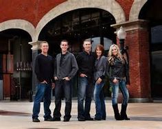 a group of people standing next to each other in front of a red brick building