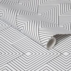 an abstract black and white wallpaper with geometric lines on the floor, as well as a roll of tape