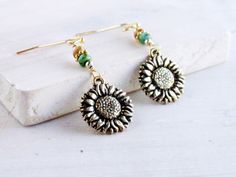 I created these delightful drop earrings in the colors of a golden autumn sunflower, with Picasso seed beads in natural and green, from which I have suspended double-sided antique gold plated sunflower charms made in the USA. The French hook ear wires are gold tone plated (nickel free) and include earring backs. These earrings measures 1 3/4 inches from the top of the earwire to the bottom of the sunflower. This is a great length as they are long enough to be seen but are still lightweight. The Adjustable Gold Sunflower Earrings, Hypoallergenic Gold Bohemian Beaded Earrings, Gold Sunflower Adjustable Flower Earrings, Bohemian Sunflower Earrings For Gift, Bohemian Sunflower Earrings As Gift, Bohemian Sunflower Design Earrings For Gift, Gold Sunflower Dangle Jewelry, Bohemian Sunflower Design Flower Earrings As Gift, Bohemian Sunflower Drop Earrings