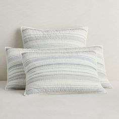 two pillows sitting next to each other on a bed