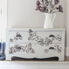 a white dresser with flowers painted on it