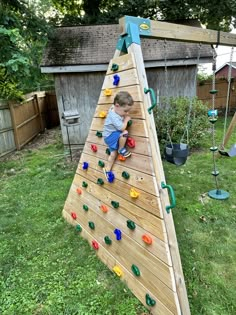 a young boy climbing up the side of a wooden tree